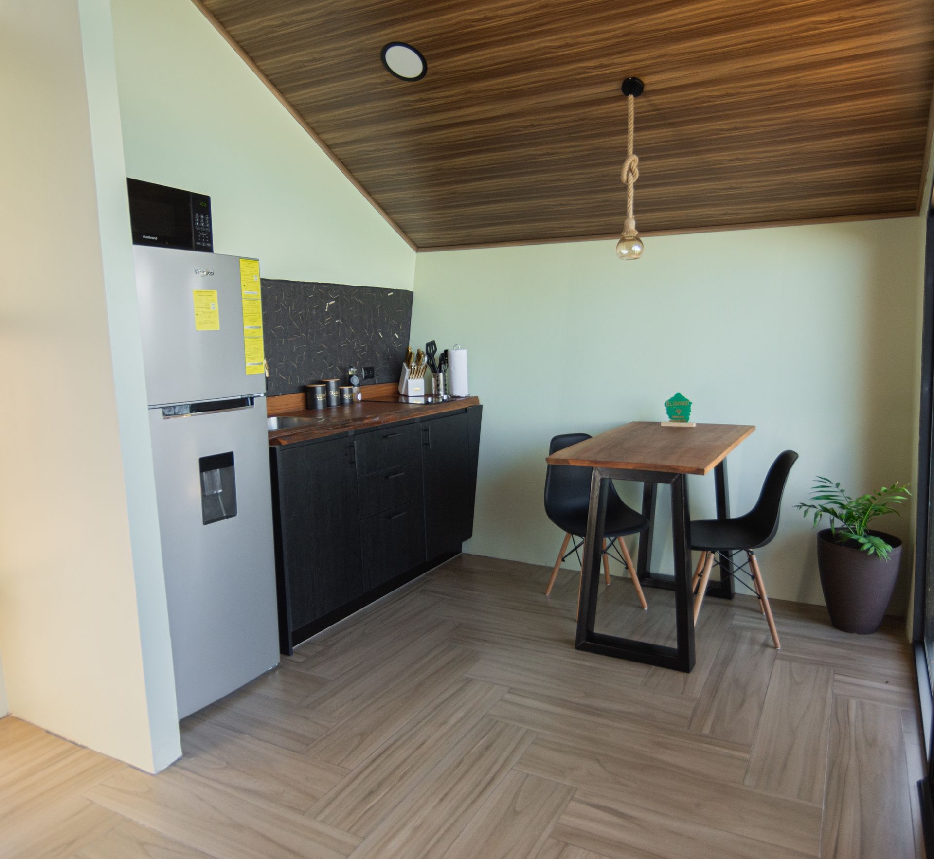 Cocina equipada con refrigeradora y comedor para dos
